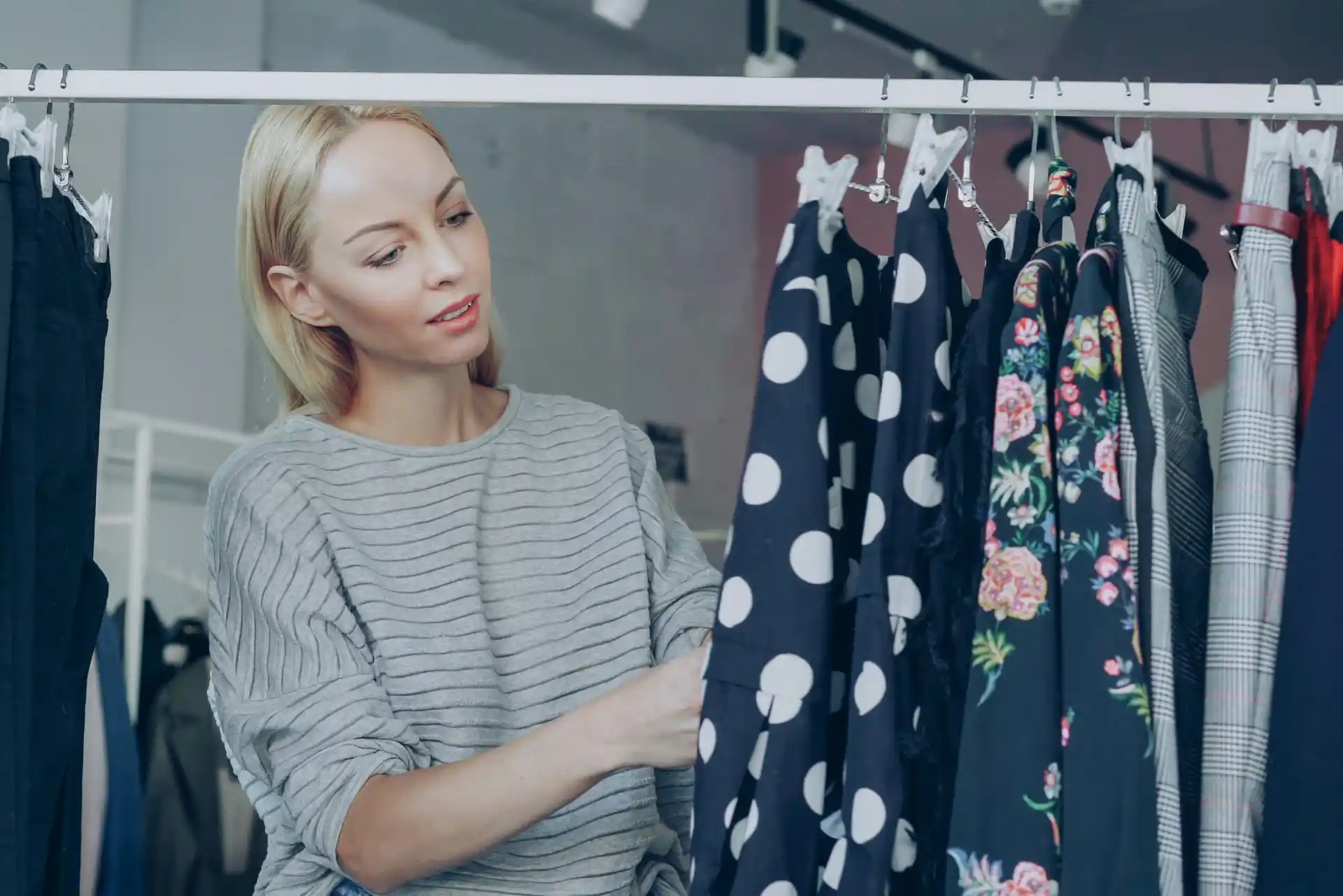 mujer buscando una prenda en perchero